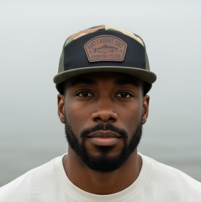 Ain’t Caught Shit Fishing Club – Camo 7-Panel Trucker Hat